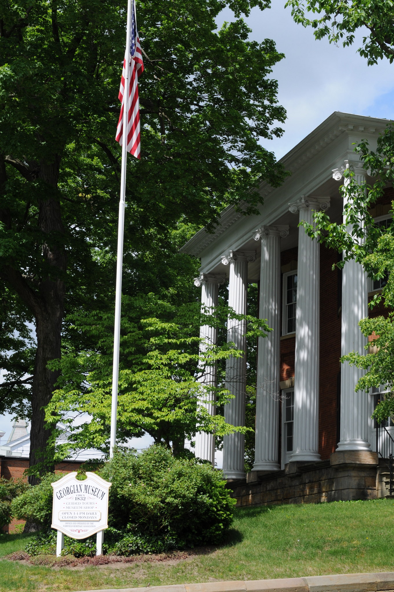 The brick and sandstone facade of the Georgian Museum behind its two-storied portico of fluted Ionic columns